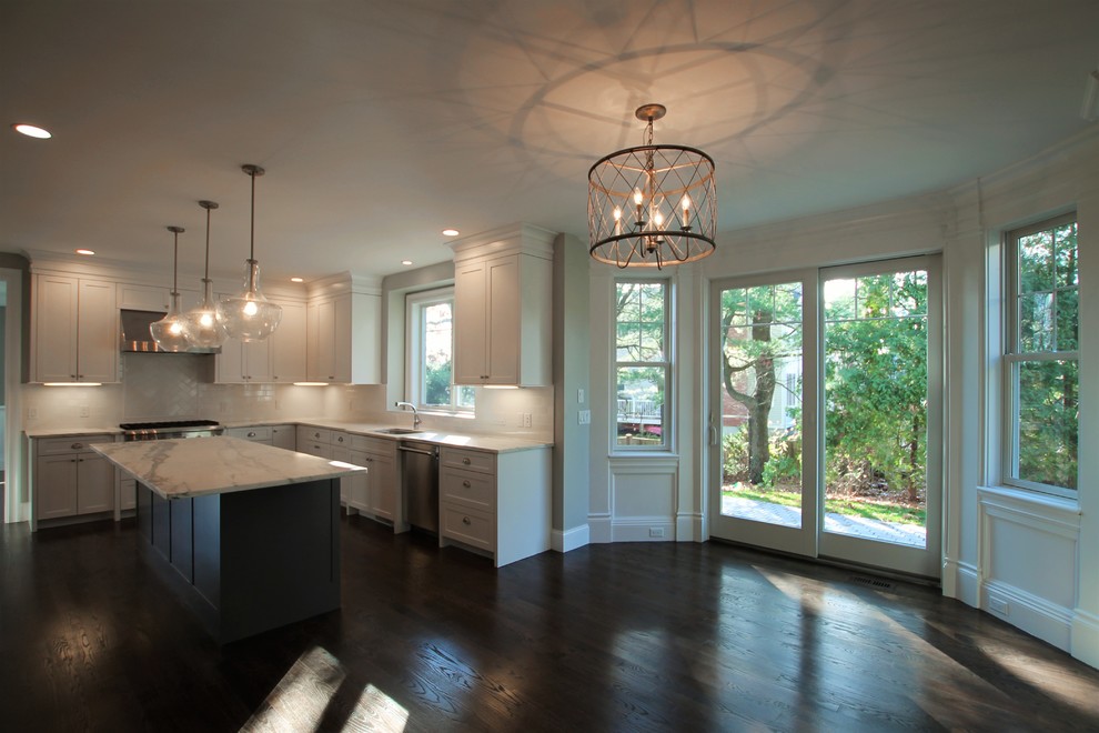 Eat-in kitchen - mid-sized transitional u-shaped dark wood floor and brown floor eat-in kitchen idea in Boston with an undermount sink, shaker cabinets, white cabinets, marble countertops, white backsplash, porcelain backsplash, stainless steel appliances and an island