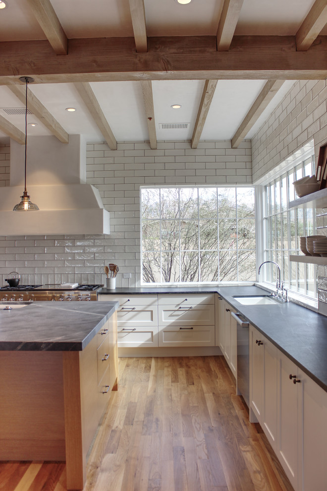 Inspiration for a large transitional u-shaped medium tone wood floor and brown floor open concept kitchen remodel in Phoenix with shaker cabinets, white cabinets, soapstone countertops, white backsplash, ceramic backsplash, stainless steel appliances and an island