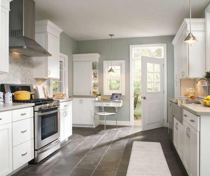 Kitchen - mid-sized transitional galley plywood floor kitchen idea with an undermount sink, shaker cabinets, white cabinets, granite countertops, white backsplash, subway tile backsplash and stainless steel appliances