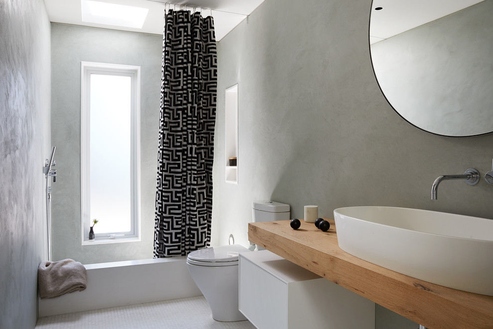 Alcove bathtub - mid-sized contemporary master mosaic tile floor and white floor alcove bathtub idea in San Francisco with a vessel sink, flat-panel cabinets, white cabinets, gray walls, wood countertops and brown countertops