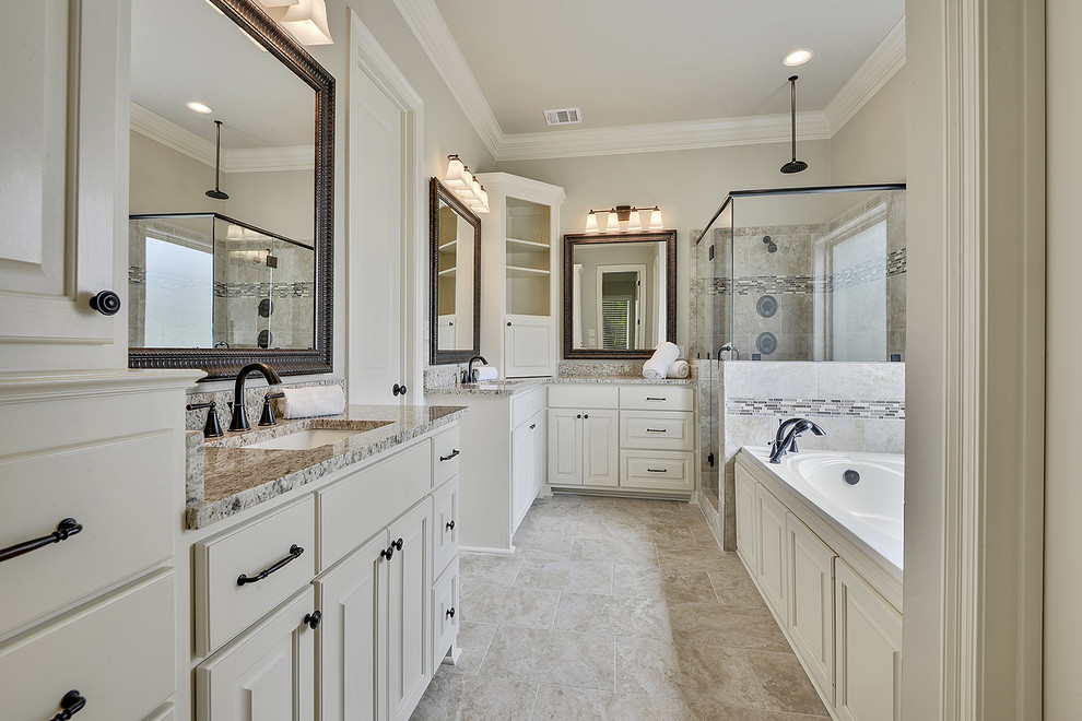 This is an example of a large traditional master bathroom in New Orleans with raised-panel cabinets, white cabinets, an alcove tub, a corner shower, a two-piece toilet, beige tile, ceramic tile, beige walls, ceramic floors, an undermount sink, granite benchtops, beige floor and a hinged shower door.