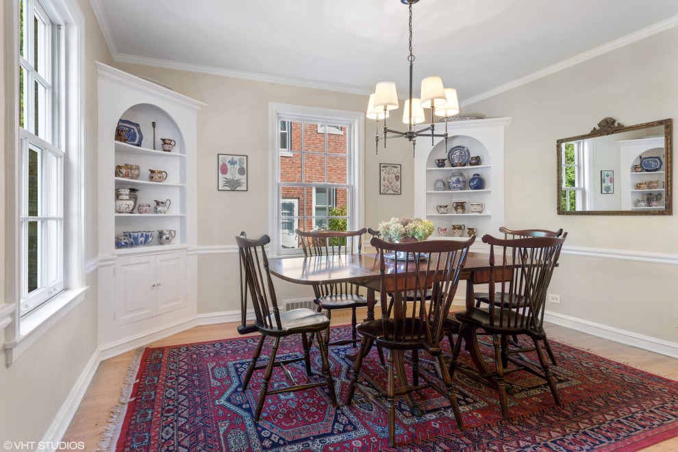 This is an example of a mid-sized traditional separate dining room in Chicago with beige walls and light hardwood floors.