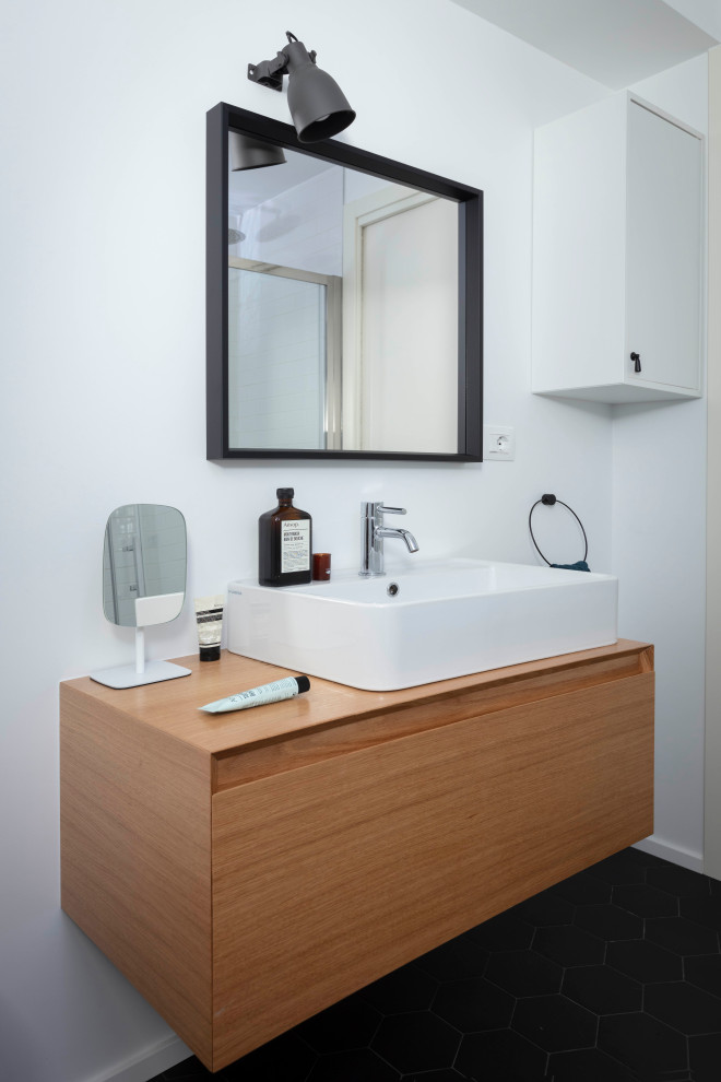 Esempio di una piccola stanza da bagno industriale con ante in legno chiaro, pareti bianche, top in legno e pavimento nero