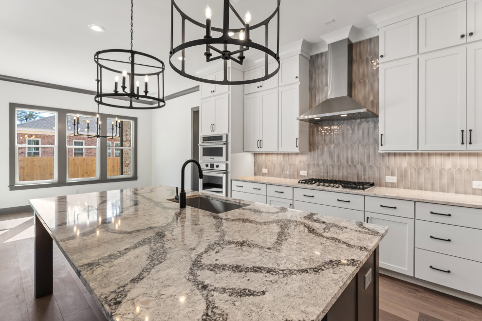 Inspiration for a mid-sized transitional l-shaped medium tone wood floor and brown floor open concept kitchen remodel with an undermount sink, recessed-panel cabinets, white cabinets, quartz countertops, beige backsplash, ceramic backsplash, stainless steel appliances, an island and beige countertops