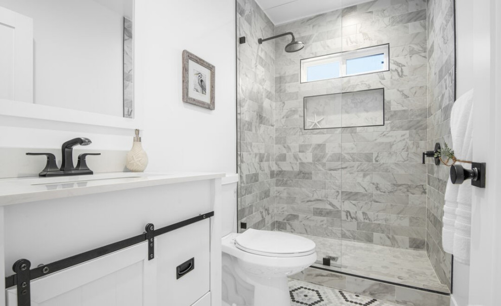 This is an example of a contemporary bathroom in Los Angeles with flat-panel cabinets, white cabinets, an alcove shower, a one-piece toilet, white walls, mosaic tile floors, an undermount sink, solid surface benchtops, grey floor, a hinged shower door, white benchtops, a niche, a single vanity and a built-in vanity.