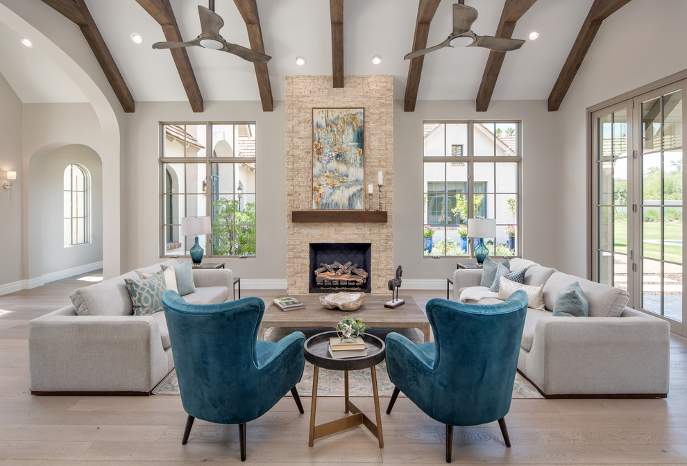 Design ideas for a transitional formal open concept living room in Phoenix with beige walls, light hardwood floors, a standard fireplace, a stone fireplace surround, no tv and beige floor.