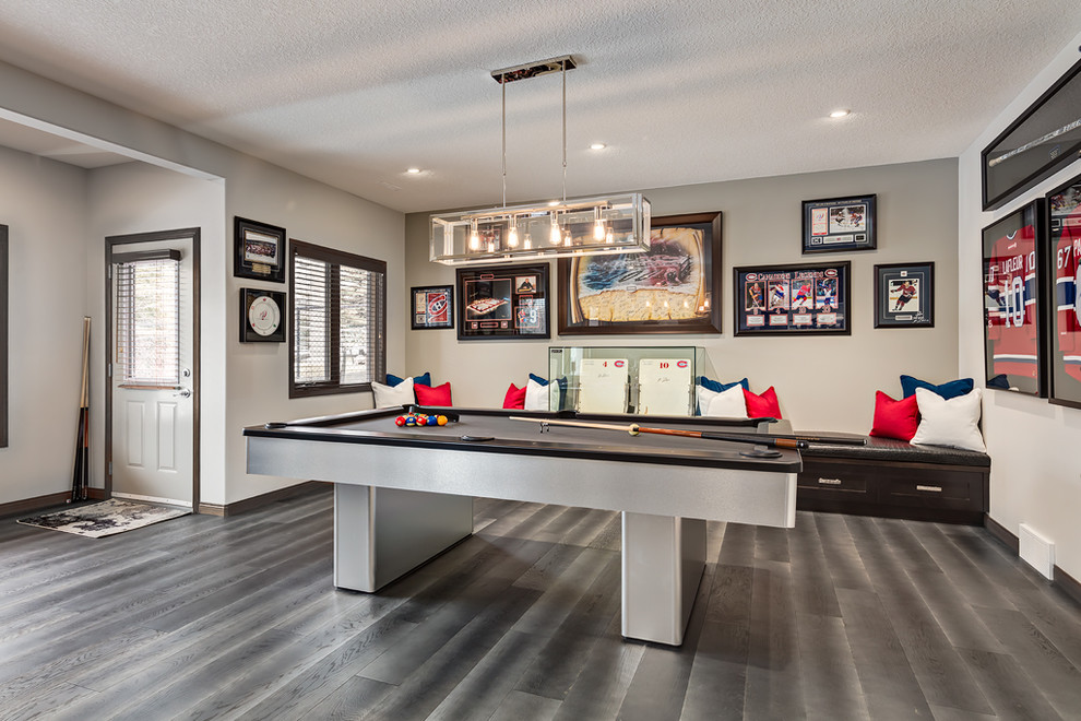 Example of a large transitional walk-out medium tone wood floor and gray floor basement design in Calgary with gray walls