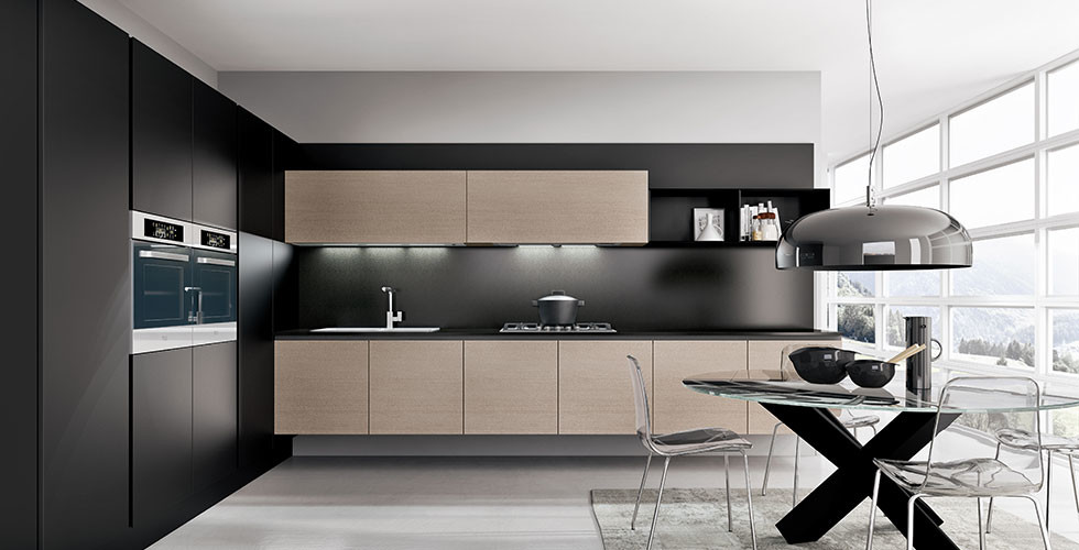 Photo of a small modern l-shaped eat-in kitchen in Orange County with flat-panel cabinets, light wood cabinets, black splashback, stainless steel appliances, no island, grey floor and black benchtop.