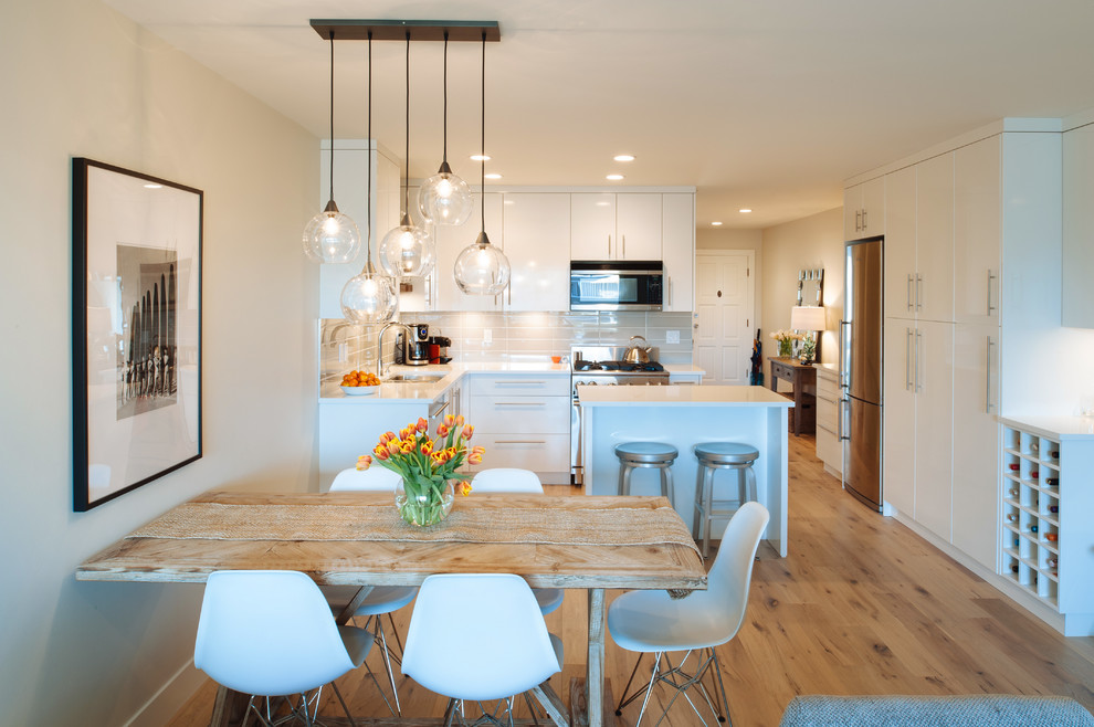 Inspiration for a small beach style open plan dining in Vancouver with white walls and light hardwood floors.