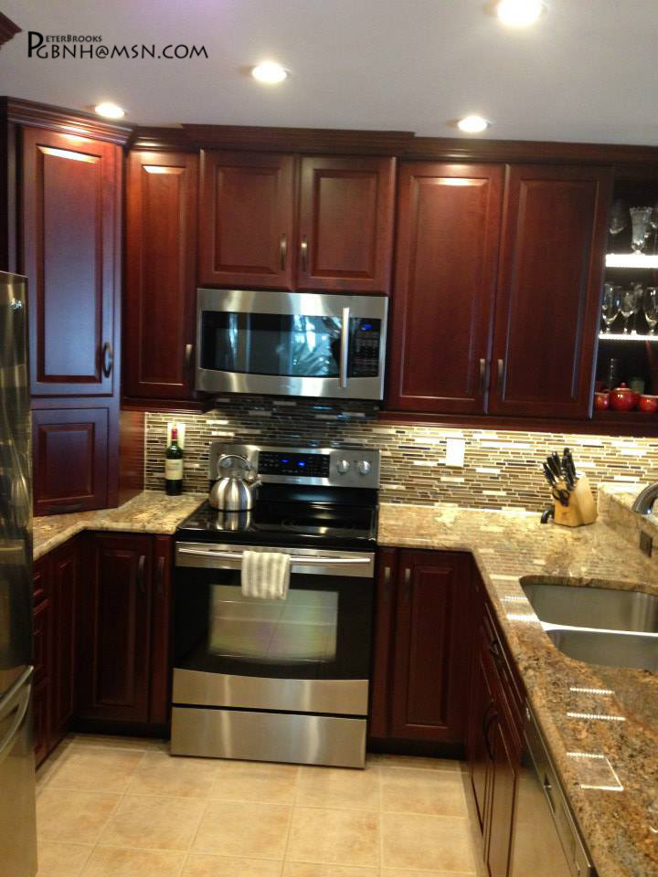 Photo of a large asian u-shaped kitchen pantry in Miami with dark wood cabinets, granite benchtops, glass tile splashback, stainless steel appliances, a double-bowl sink, raised-panel cabinets, brown splashback, ceramic floors and a peninsula.