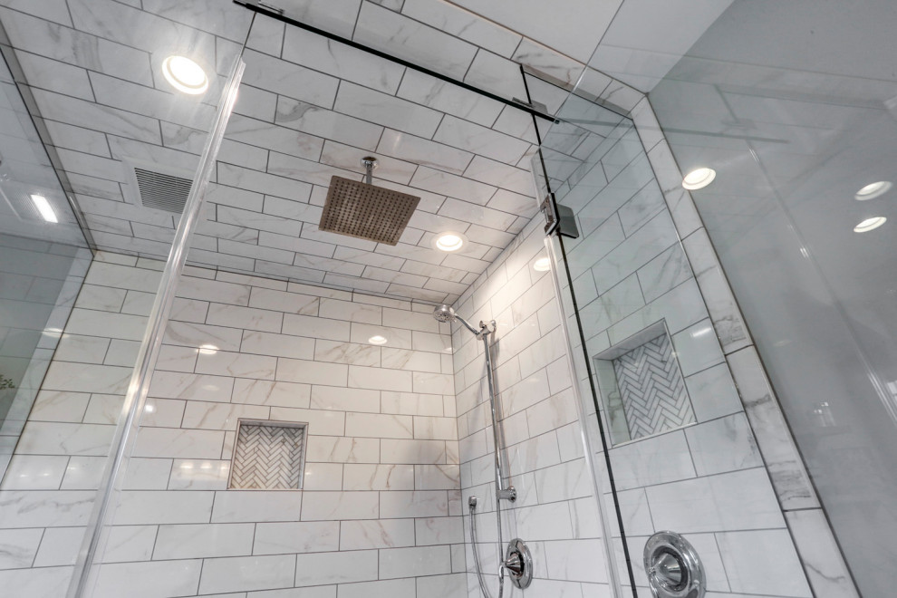 Example of a large master double-sink bathroom design with gray cabinets, gray walls, a hinged shower door and a built-in vanity