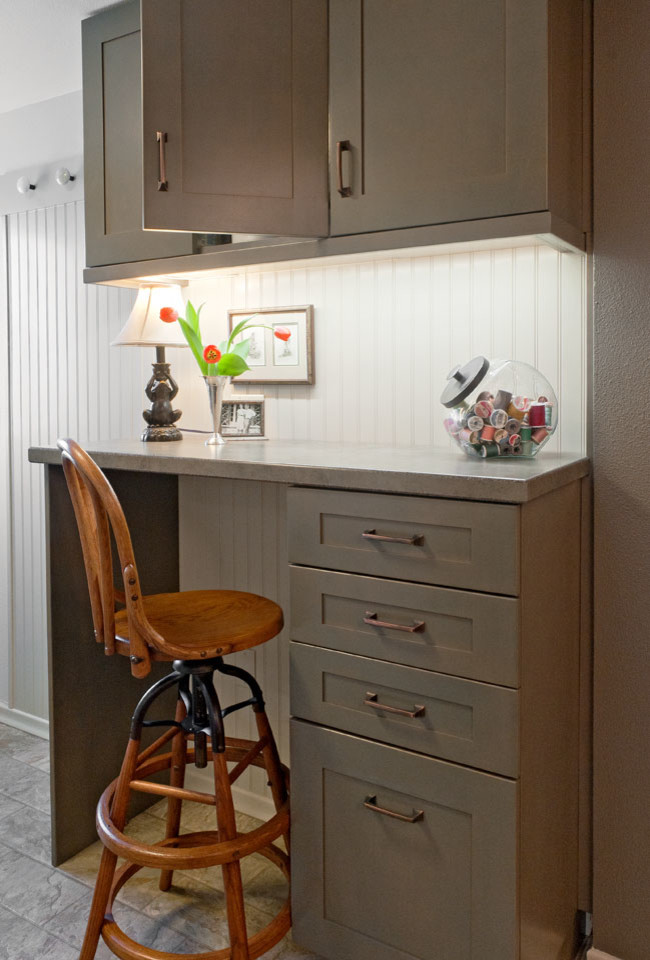 This is an example of a small arts and crafts galley utility room in Seattle with a farmhouse sink, shaker cabinets, grey cabinets, laminate benchtops, grey walls, vinyl floors and a stacked washer and dryer.