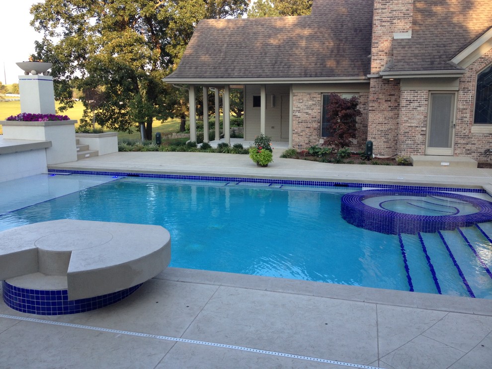 Large transitional backyard concrete paver and rectangular natural hot tub photo in Cedar Rapids