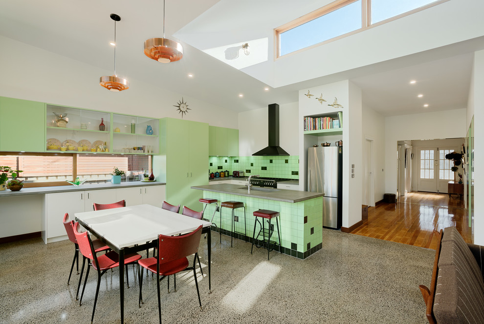 Photo of a contemporary l-shaped open plan kitchen in Melbourne with an integrated sink, flat-panel cabinets, green cabinets, concrete benchtops, green splashback, ceramic splashback, stainless steel appliances, concrete floors and with island.