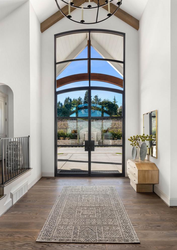 Esempio di un ampio ingresso con pareti bianche, pavimento in legno massello medio, una porta a due ante, una porta in vetro e pavimento marrone