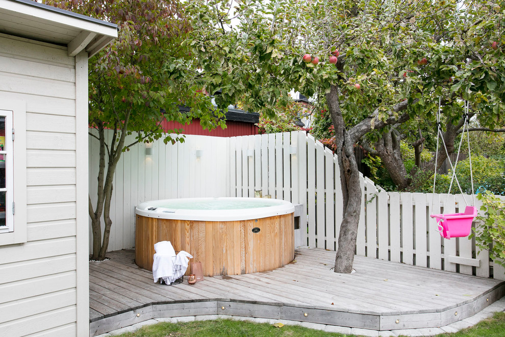 Small transitional backyard round pool in Malmo with decking.