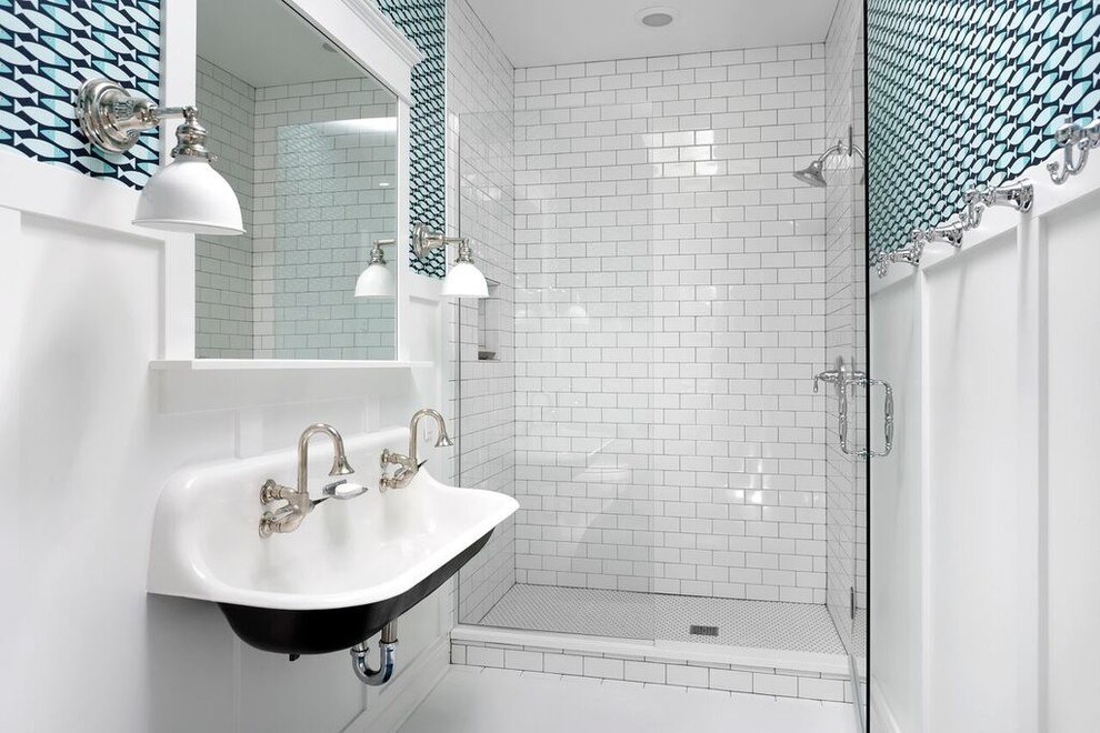 Photo of a beach style kids bathroom in Chicago with white tile, multi-coloured walls, a trough sink and a hinged shower door.