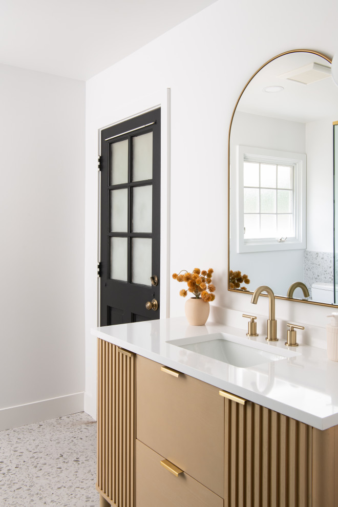 Photo of a mid-sized beach style master bathroom in Orange County with shaker cabinets, medium wood cabinets, a corner shower, a one-piece toilet, white tile, porcelain tile, white walls, terrazzo floors, a drop-in sink, marble benchtops, a hinged shower door, white benchtops, a niche, a single vanity and a freestanding vanity.
