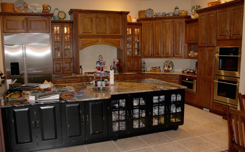 Large mediterranean l-shaped open plan kitchen in Phoenix with an undermount sink, raised-panel cabinets, distressed cabinets, granite benchtops, stainless steel appliances, porcelain floors and with island.