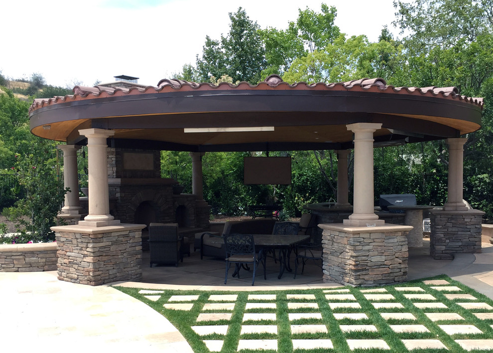 Design ideas for a large mediterranean backyard patio in Los Angeles with an outdoor kitchen, natural stone pavers and a pergola.