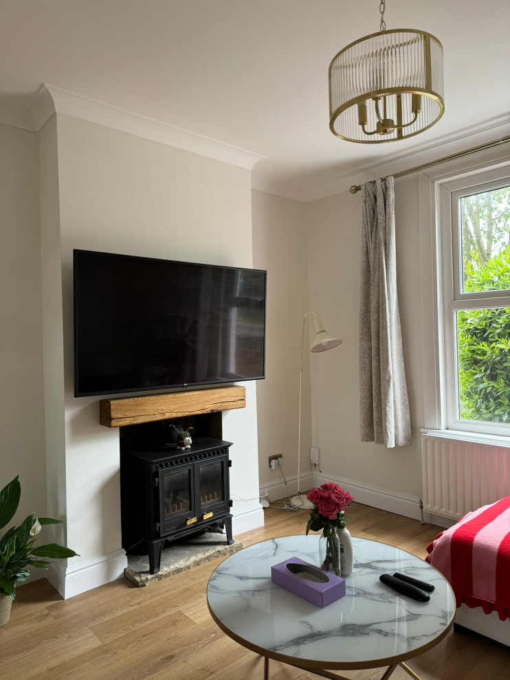 This is an example of a medium sized modern formal and grey and white enclosed living room in London with white walls, light hardwood flooring, a standard fireplace, a metal fireplace surround, a wall mounted tv, multi-coloured floors, a timber clad ceiling and feature lighting.