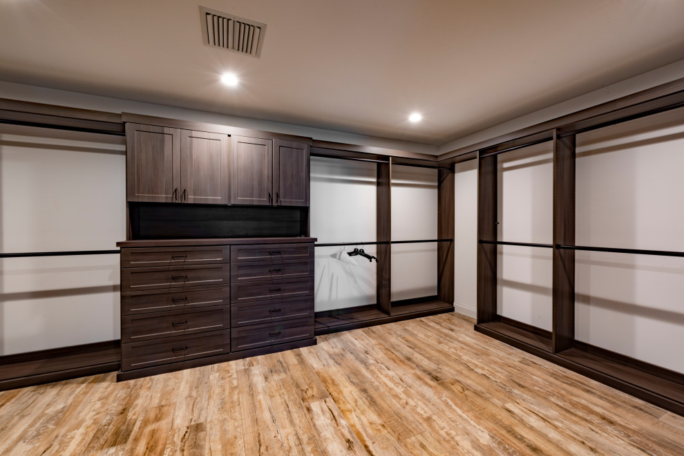 Design ideas for a large contemporary gender-neutral dressing room in Tampa with beaded inset cabinets, brown cabinets, vinyl floors and brown floor.