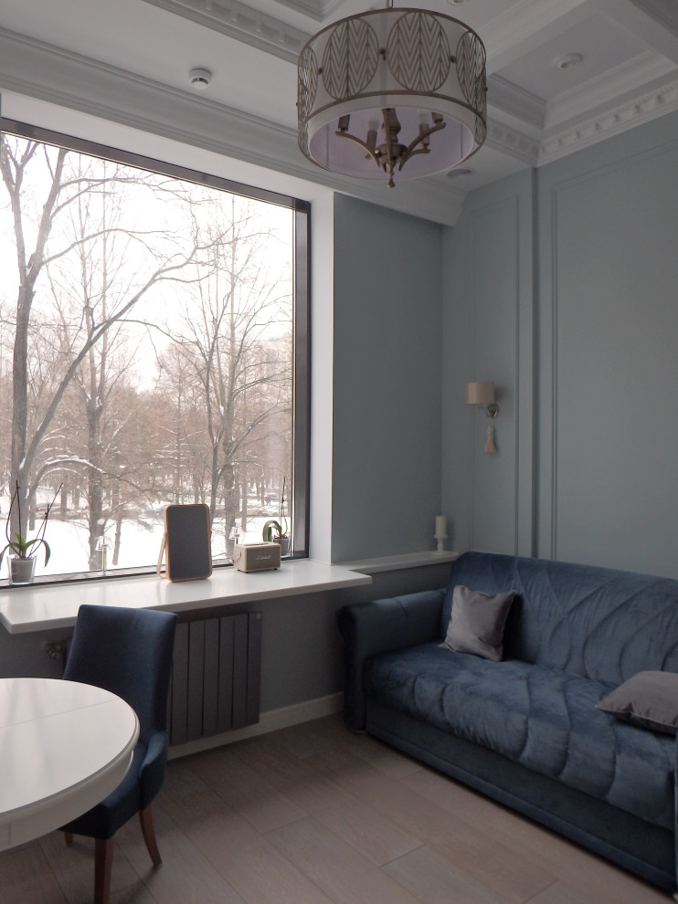 Стильный дизайн: двухуровневая гостиная комната среднего размера в стиле модернизм с синими стенами, полом из ламината, телевизором на стене, бежевым полом и кессонным потолком без камина - последний тренд