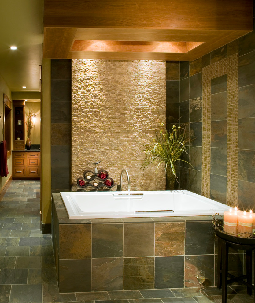 Inspiration for a large rustic master slate floor and gray floor drop-in bathtub remodel with recessed-panel cabinets, dark wood cabinets, beige walls, an undermount sink and granite countertops