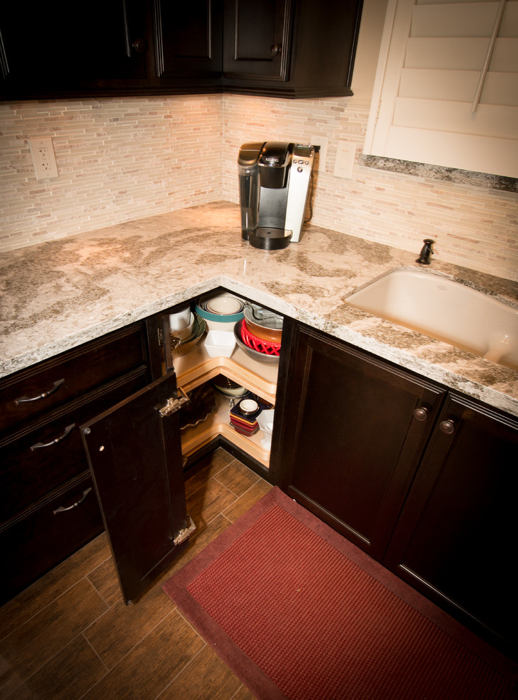 Open concept kitchen - mid-sized transitional l-shaped porcelain tile open concept kitchen idea with an undermount sink, flat-panel cabinets, dark wood cabinets, quartz countertops, beige backsplash, glass sheet backsplash, white appliances and an island