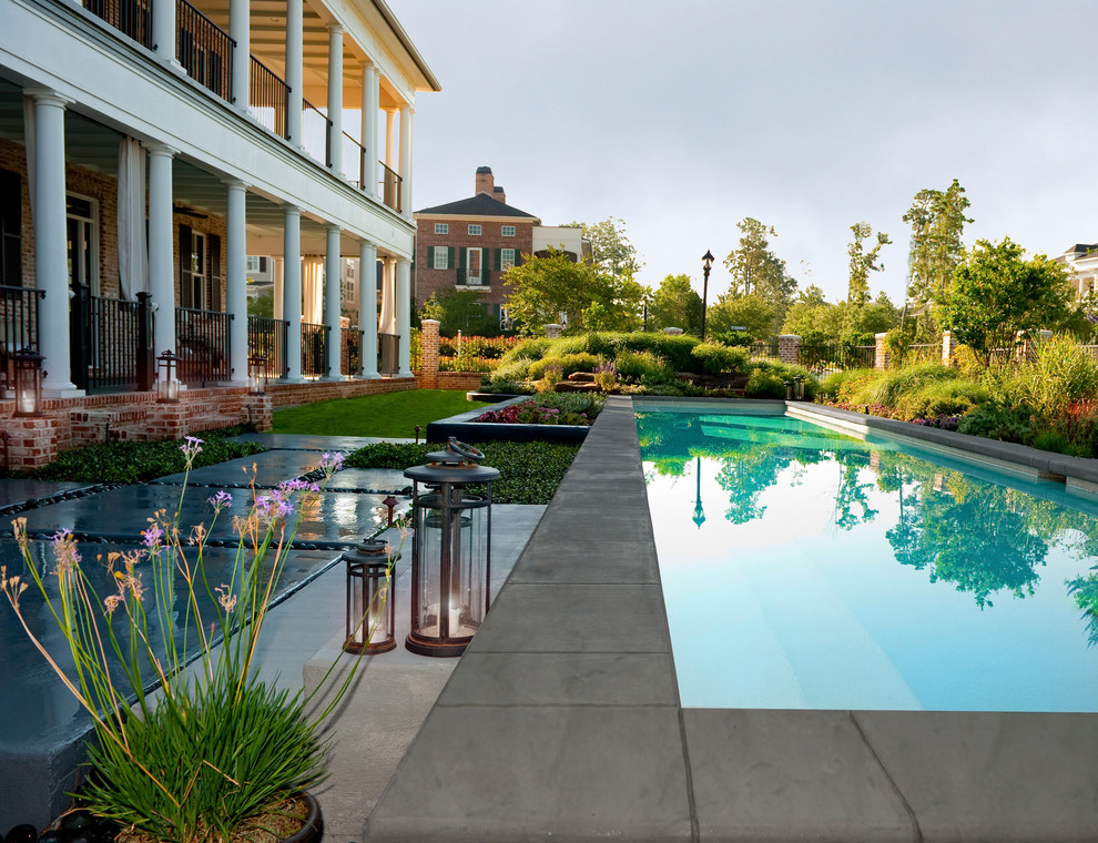 Inspiration for a mid-sized transitional backyard rectangular lap pool in Houston with concrete slab.