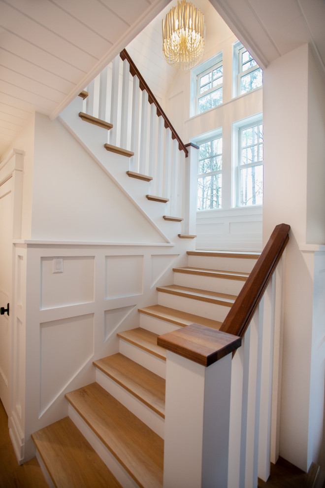 Свежая идея для дизайна: п-образная лестница среднего размера в морском стиле с деревянными ступенями, крашенными деревянными подступенками, деревянными перилами и панелями на стенах - отличное фото интерьера