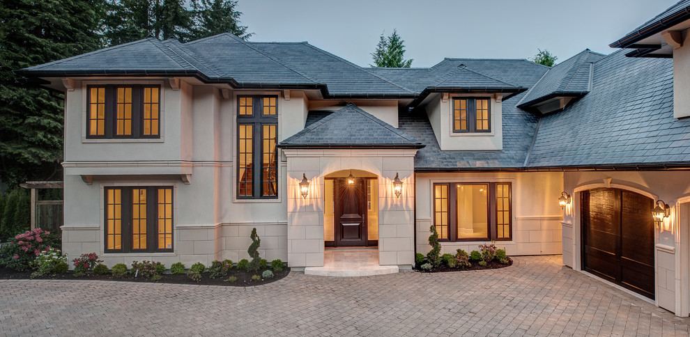 Design ideas for a traditional two-storey beige exterior in Vancouver with a hip roof.