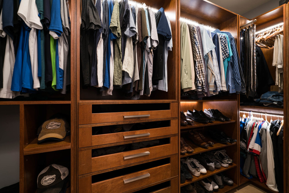 Design ideas for a large transitional men's walk-in wardrobe in Jacksonville with flat-panel cabinets, medium wood cabinets and porcelain floors.