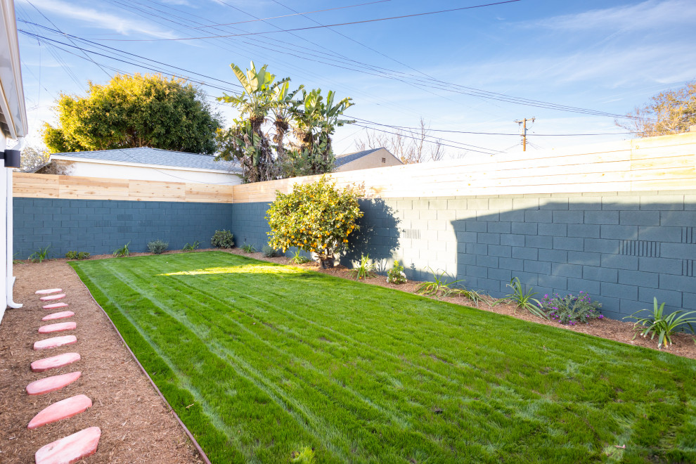 Small country backyard full sun driveway in Los Angeles with mulch and a wood fence.