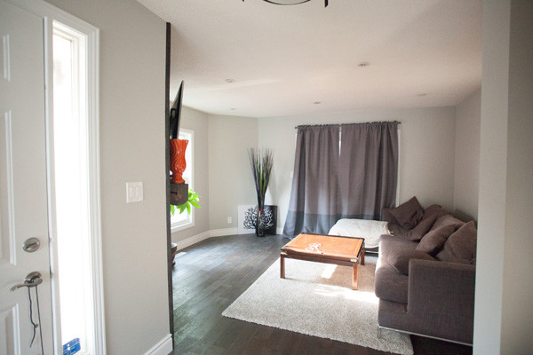 This is an example of a mid-sized transitional formal enclosed living room in San Diego with grey walls, dark hardwood floors, no fireplace and no tv.
