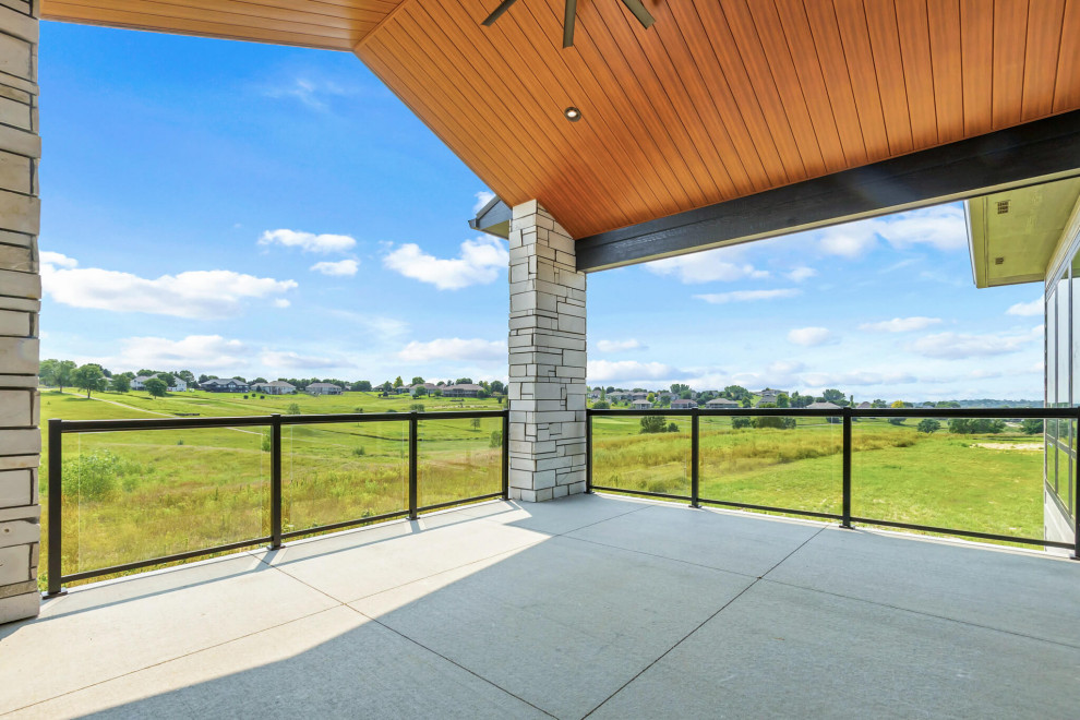 Deck - large transitional backyard ground level glass railing deck idea with a roof extension