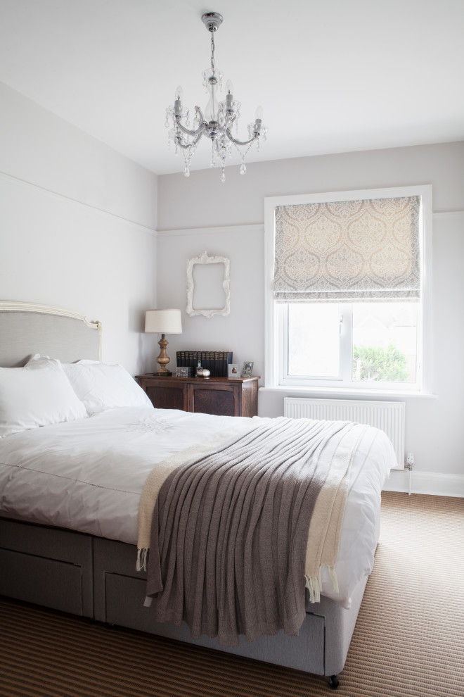 This is an example of a mid-sized traditional guest bedroom in Sussex with blue walls, carpet and beige floor.