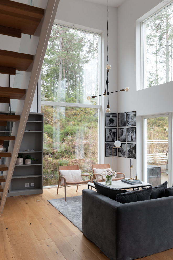 Mid-sized contemporary formal open concept living room in Stockholm with white walls, light hardwood floors, no tv and beige floor.