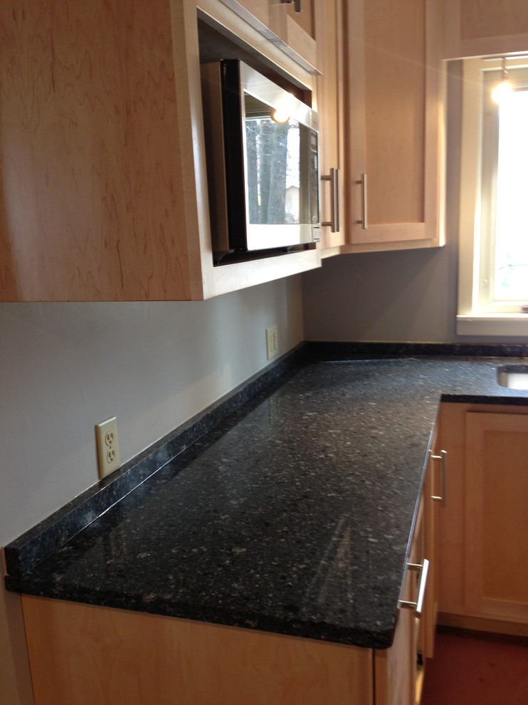 Example of a small transitional u-shaped medium tone wood floor enclosed kitchen design in Chicago with a double-bowl sink, shaker cabinets, light wood cabinets, quartzite countertops, stainless steel appliances and a peninsula