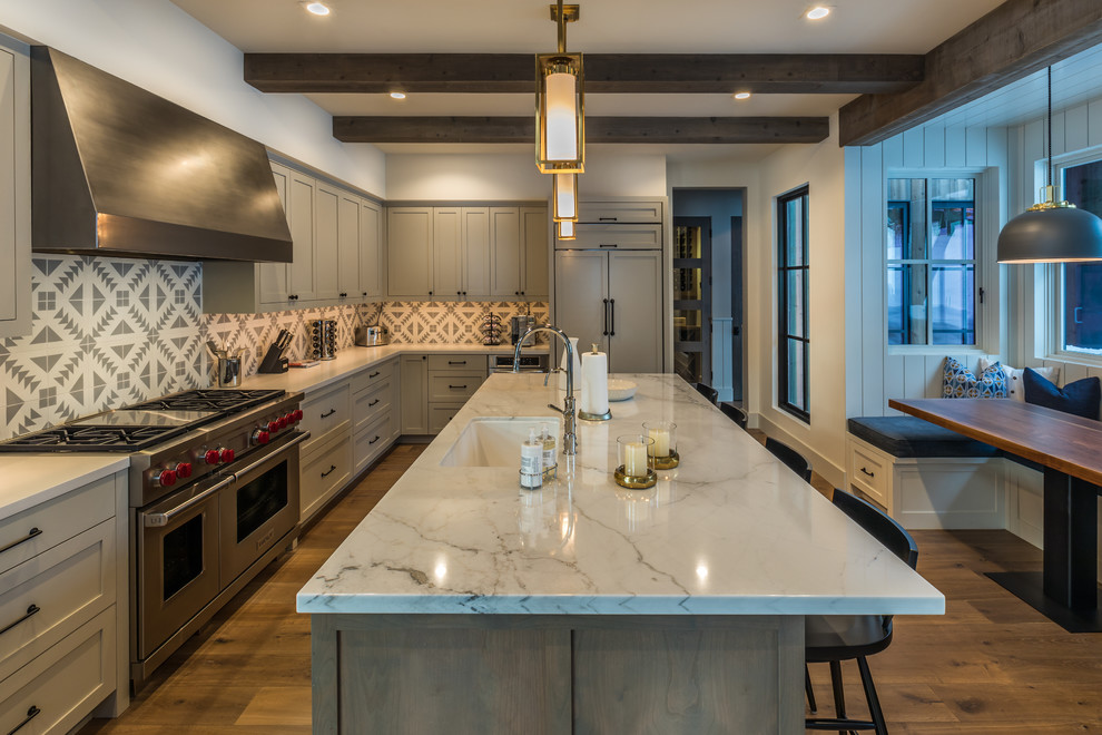 Design ideas for a mid-sized country l-shaped eat-in kitchen in Sacramento with shaker cabinets, grey cabinets, marble benchtops, medium hardwood floors, with island, brown floor, an undermount sink, grey splashback and panelled appliances.