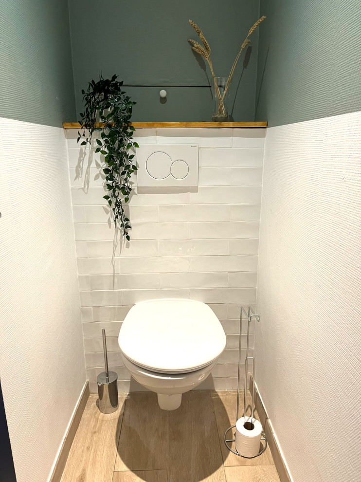 Kleine Moderne Gästetoilette mit Wandtoilette, weißen Fliesen, Keramikfliesen, grüner Wandfarbe, Keramikboden, gefliestem Waschtisch, beigem Boden und weißer Waschtischplatte in Paris
