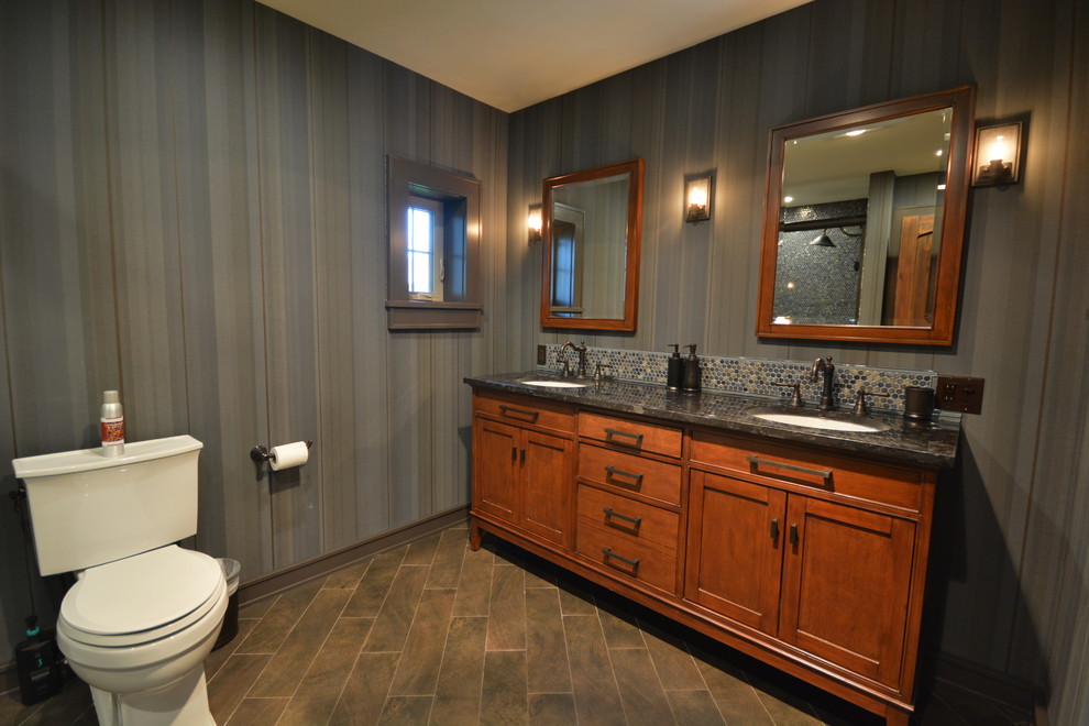 Design ideas for a large country kids bathroom in New York with shaker cabinets, medium wood cabinets, an alcove tub, a one-piece toilet, blue tile, mosaic tile, blue walls, porcelain floors, an undermount sink, granite benchtops and brown floor.