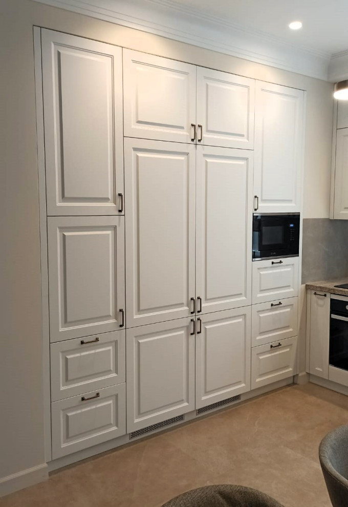 Угловая кухня в белом цвете с раковиной у окна