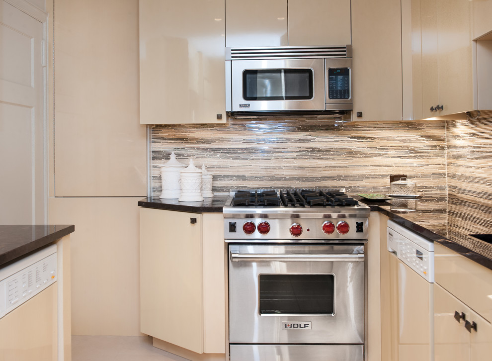 Photo of a mid-sized transitional u-shaped separate kitchen in New York with an undermount sink, flat-panel cabinets, light wood cabinets, solid surface benchtops, multi-coloured splashback, porcelain splashback, stainless steel appliances and porcelain floors.