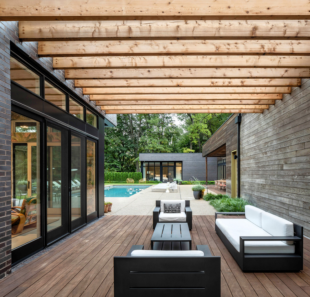 Cette image montre une terrasse arrière et au rez-de-chaussée minimaliste avec des solutions pour vis-à-vis et une pergola.