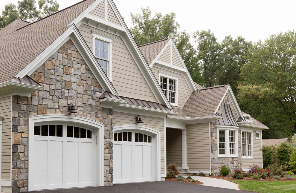 This is an example of a large traditional two-storey beige exterior in Boston with mixed siding and a hip roof.