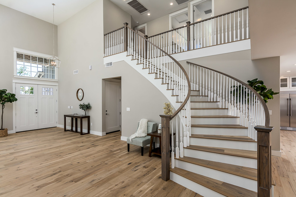 Transitional medium tone wood floor and brown floor foyer photo in Phoenix with beige walls and a white front door
