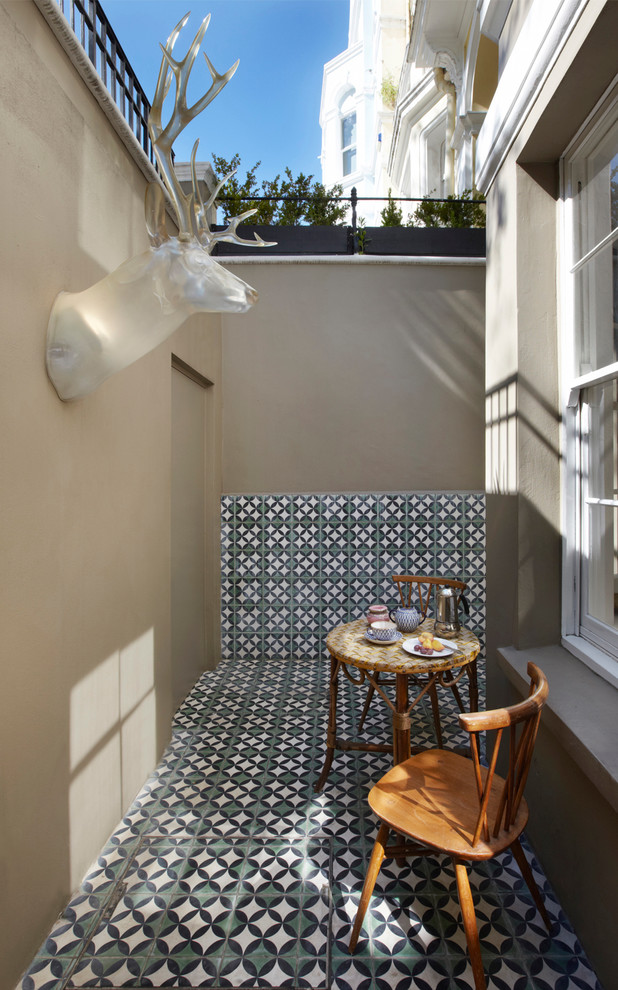 Photo of a small eclectic patio in London with tile and no cover.