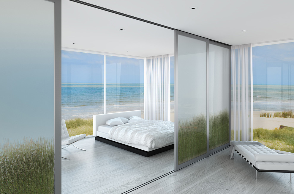 Inspiration for a large beach style master bedroom in Los Angeles with light hardwood floors and grey floor.
