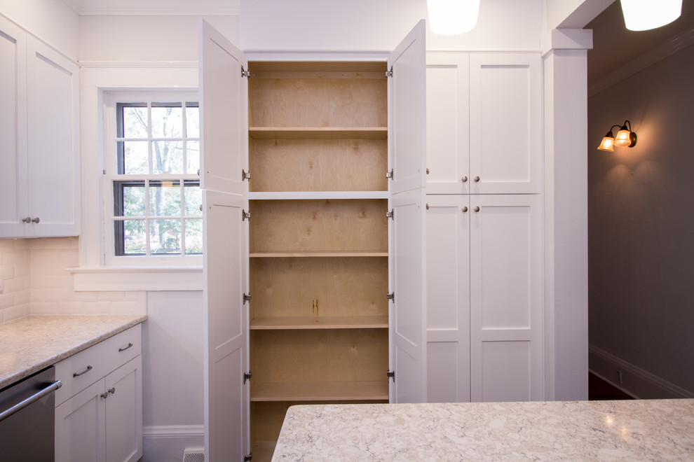 Small u-shaped ceramic tile eat-in kitchen photo with an undermount sink, shaker cabinets, white cabinets, quartz countertops, white backsplash, subway tile backsplash, stainless steel appliances, an island and white countertops